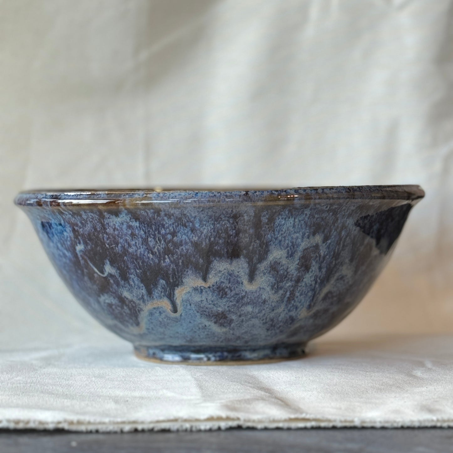 Blue ceramic bowl on a light fabric background