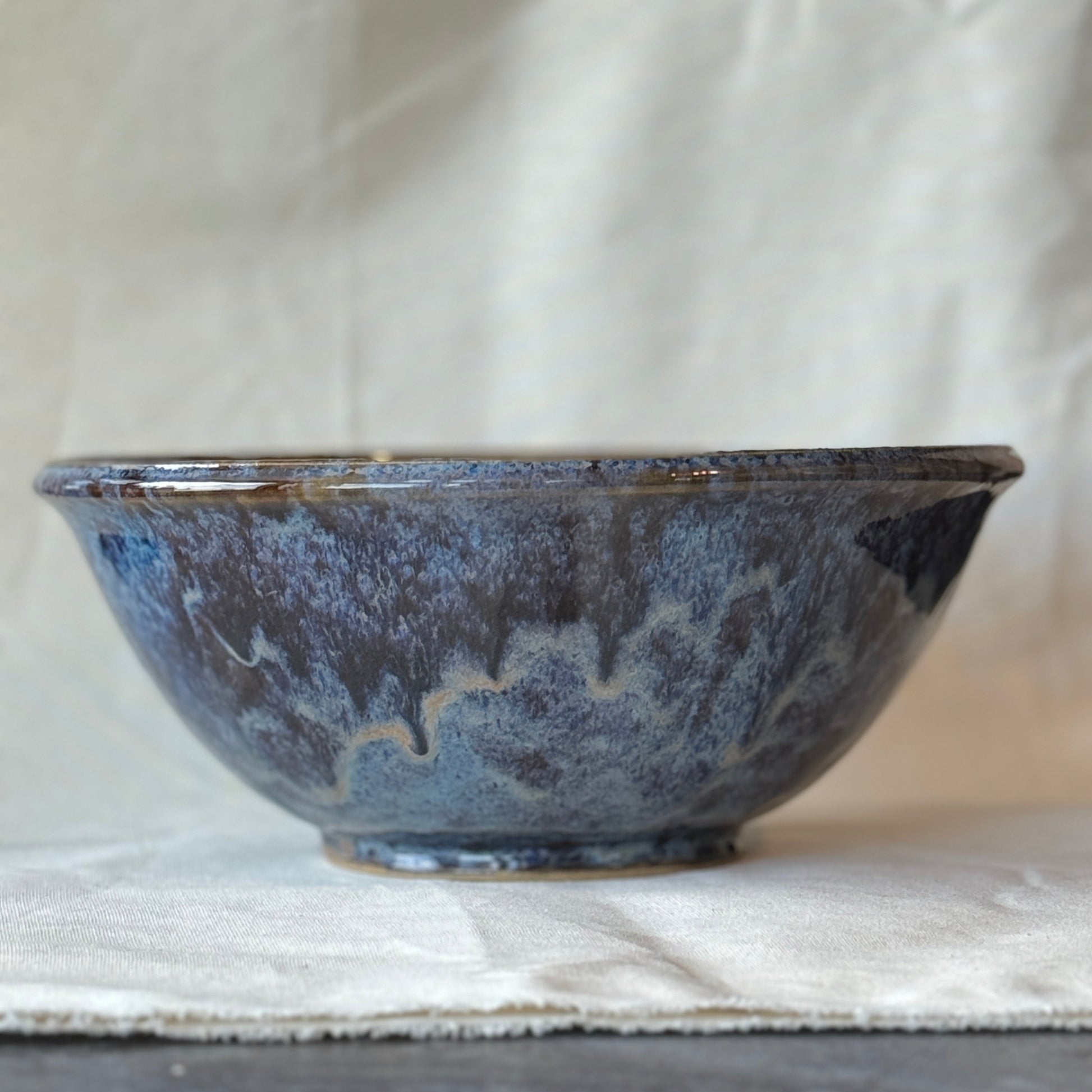Blue ceramic bowl on a light fabric background