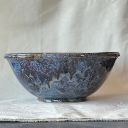Blue ceramic bowl on a light fabric background