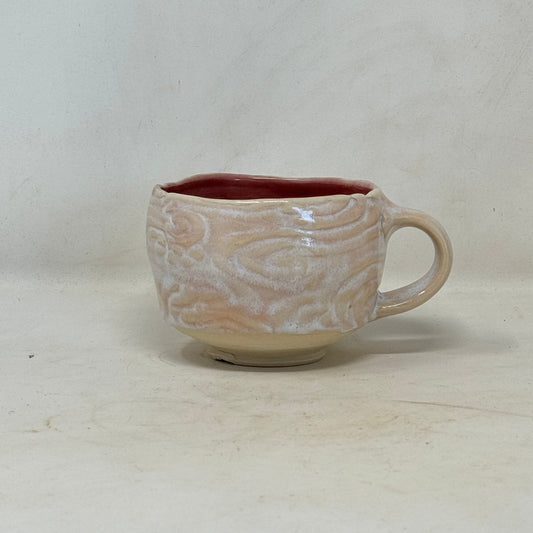 Ceramic mug with a textured design on a plain background