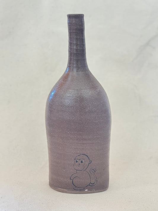 Gray textured bottle with a small design on a light gray background