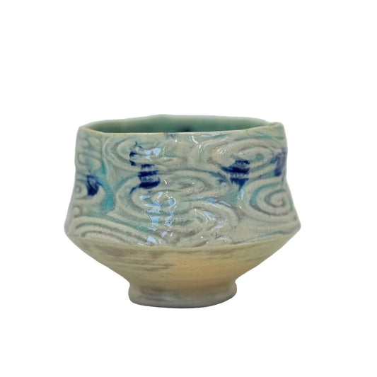 Ceramic bowl with blue wave patterns on a white background