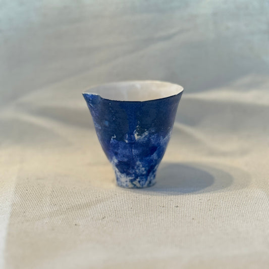 Blue ceramic cup on a textured white surface