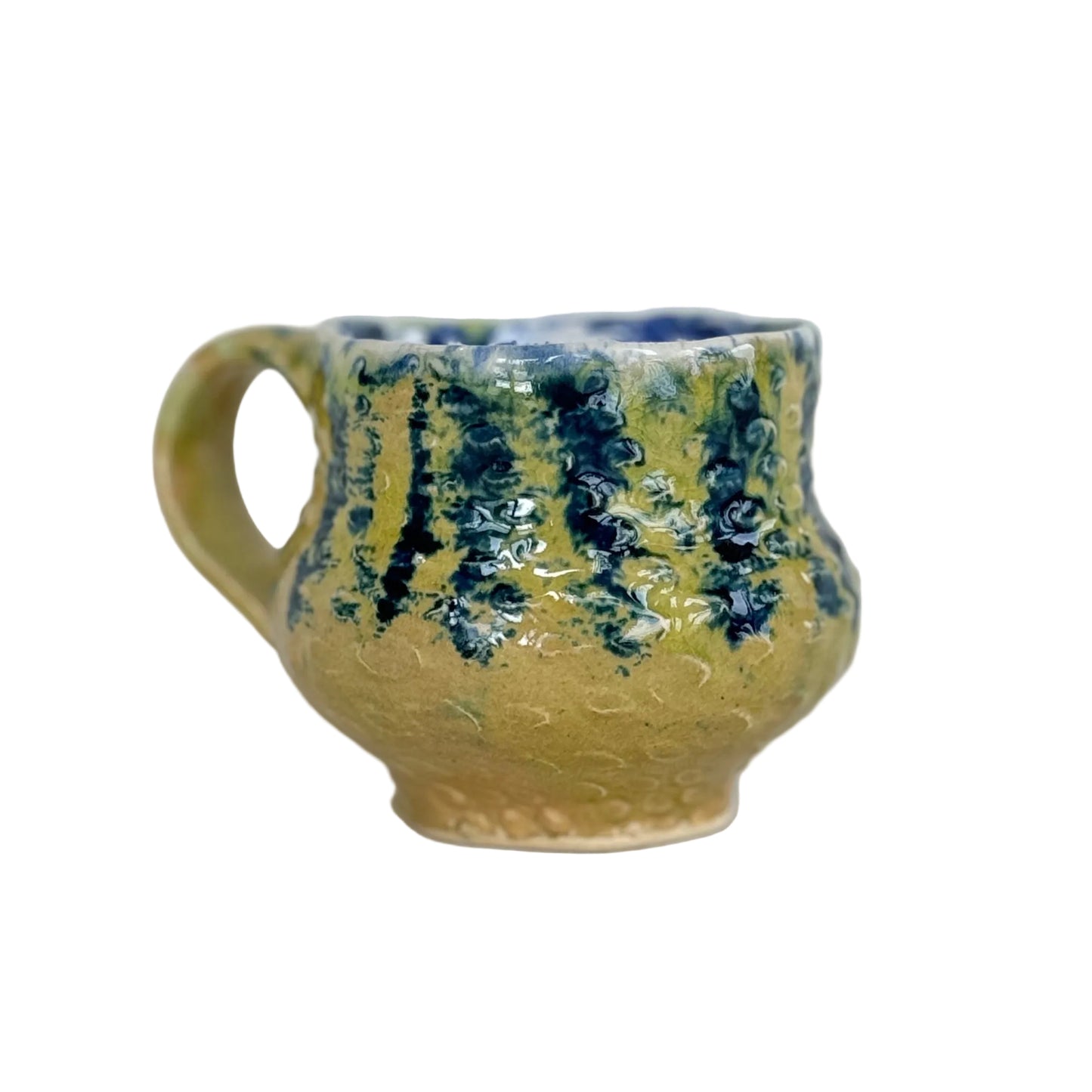 Ceramic mug with blue and green patterns on a white background