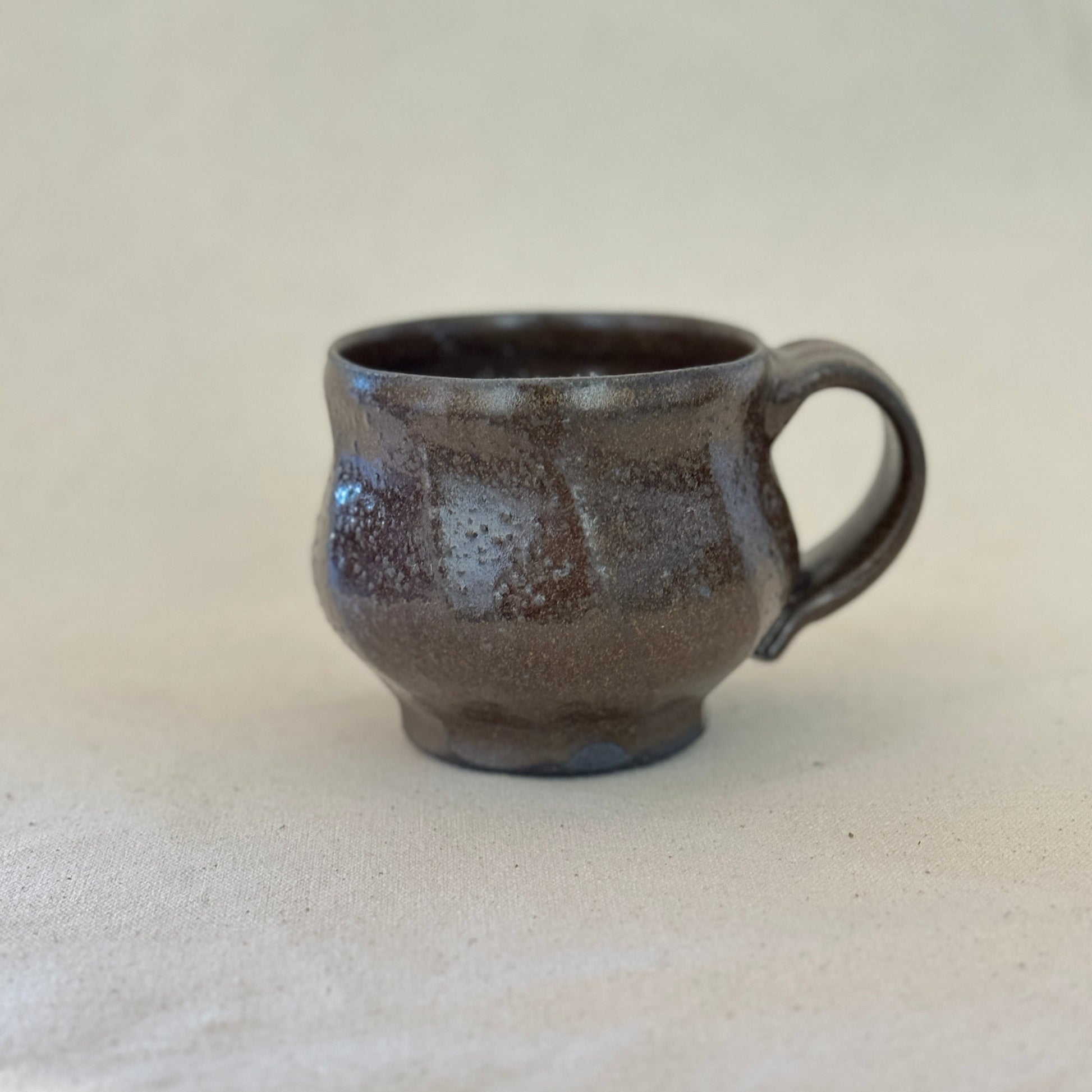 Brown ceramic mug on a light gray background