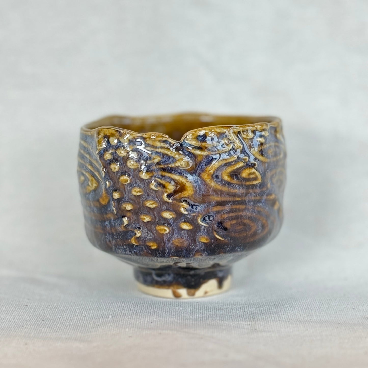 Ceramic cup with textured design on a light gray background