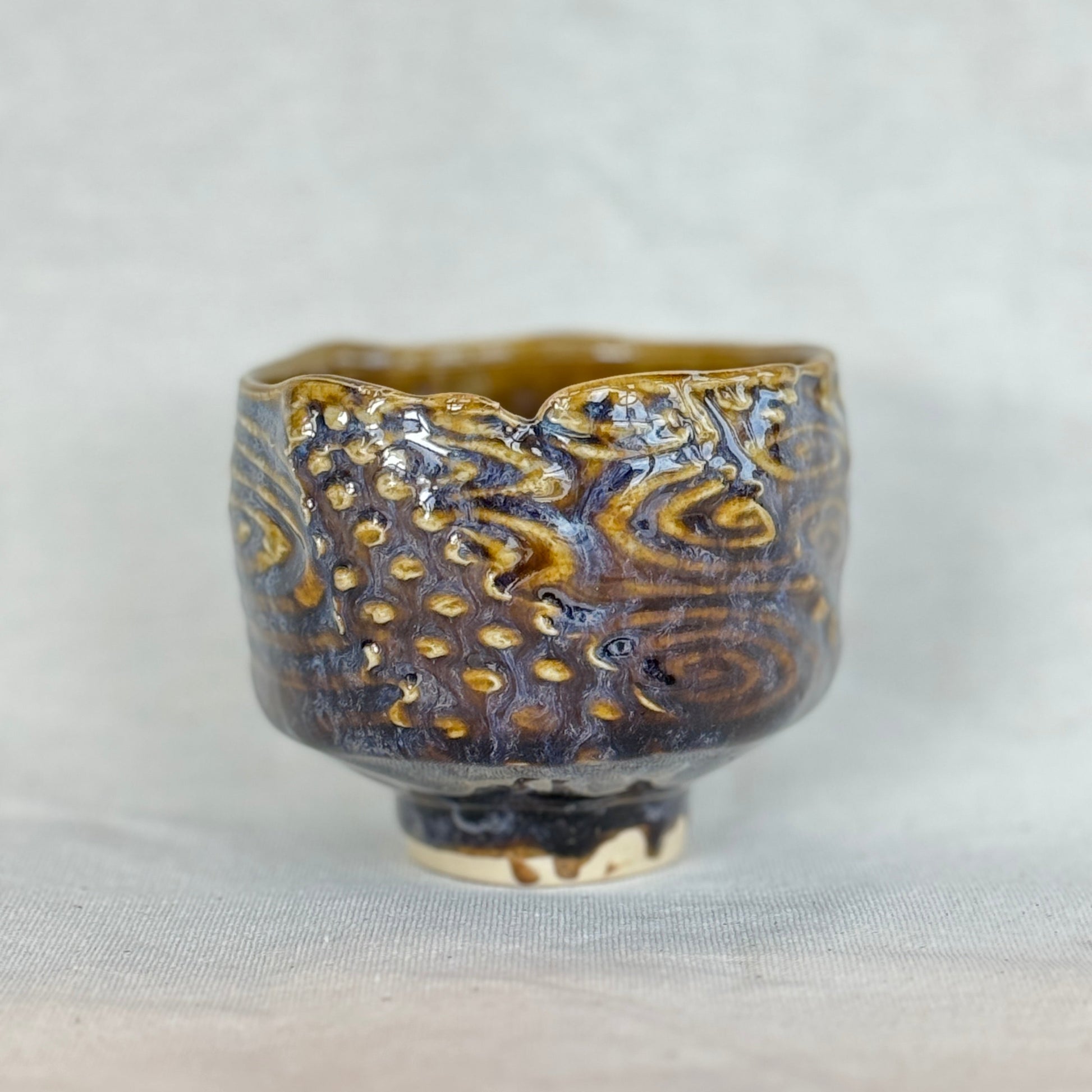 Ceramic cup with textured design on a light gray background