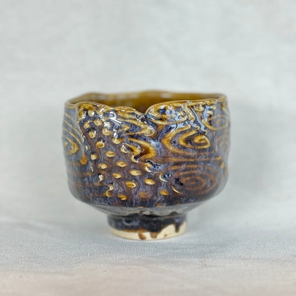 Ceramic cup with textured design on a light gray background