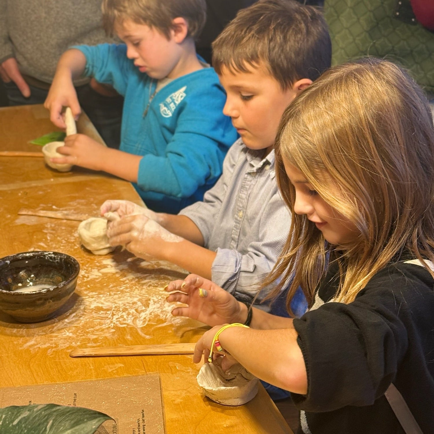 Children making crafts at a table with various materials