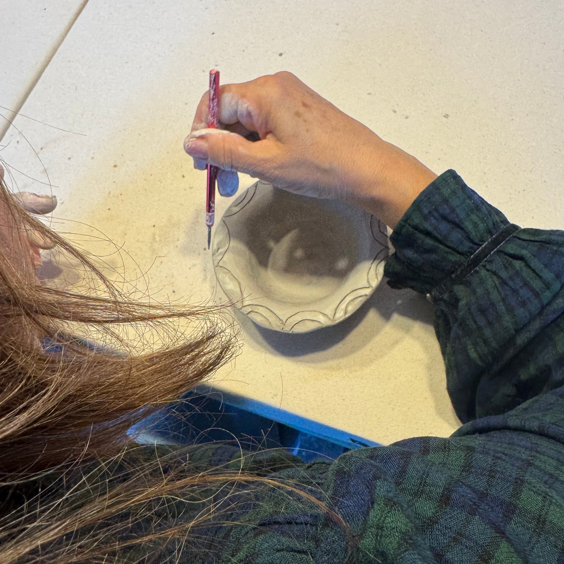 Person trimming pottery