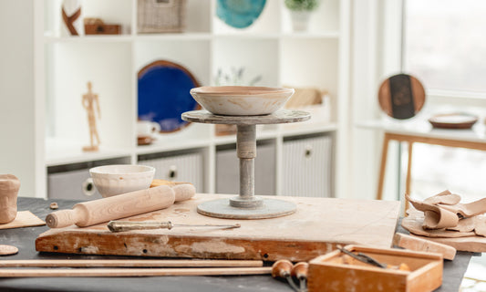 Ceramic tools and a stand on a table with a blurred kitchen background